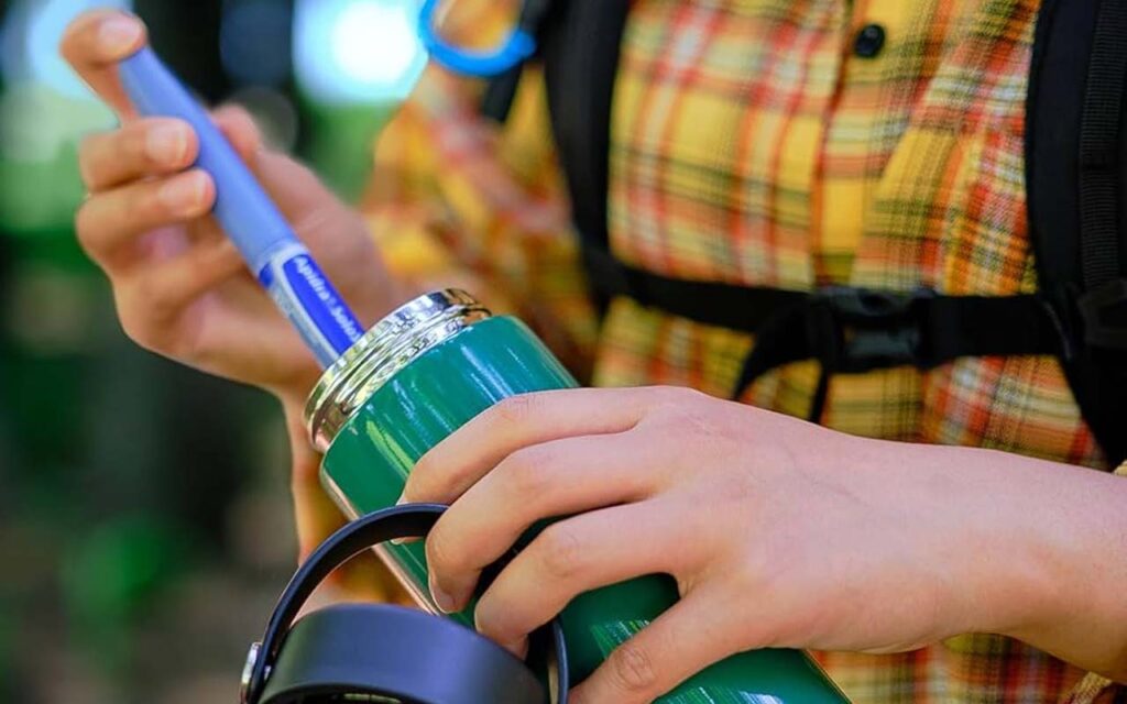 Person packing glp-1 medication into thermos for safe traveling. Ness Healthcare