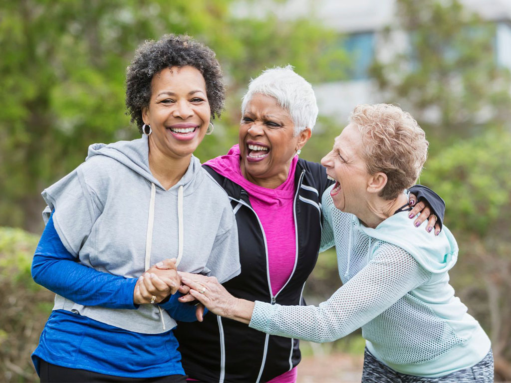 Three older ladies laughing and hugging, careone, ness